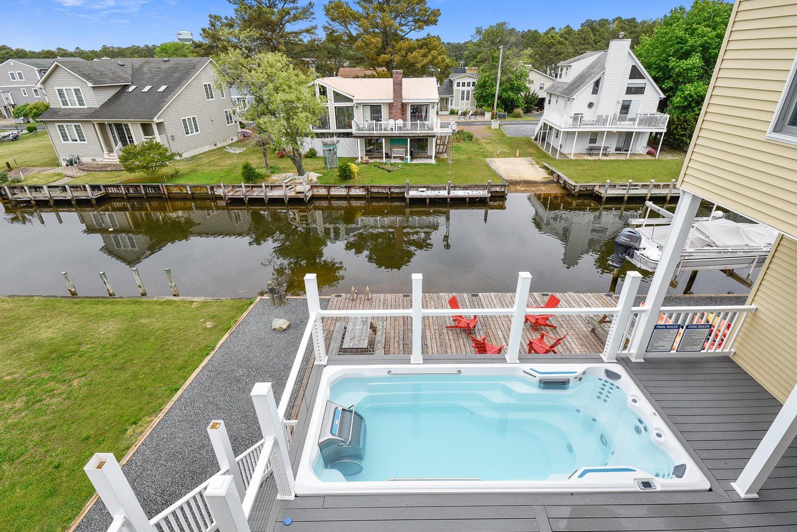 A residential area with a swimming pool, dock, and houses.