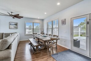 A dining area with a wooden table, chairs, and a ceiling fan.