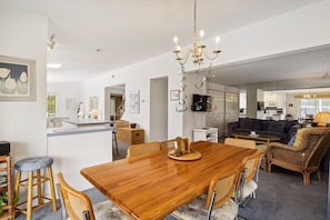 A modern living space with a dining area, kitchen, and seating area.