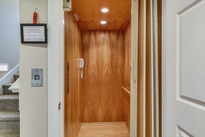 A wooden elevator with a call button and a phone. - Amazing 6 BR Oceanside Property in Bethany Beach: Elevator, Hot Tub, Sleeps 15! (South Bethany)