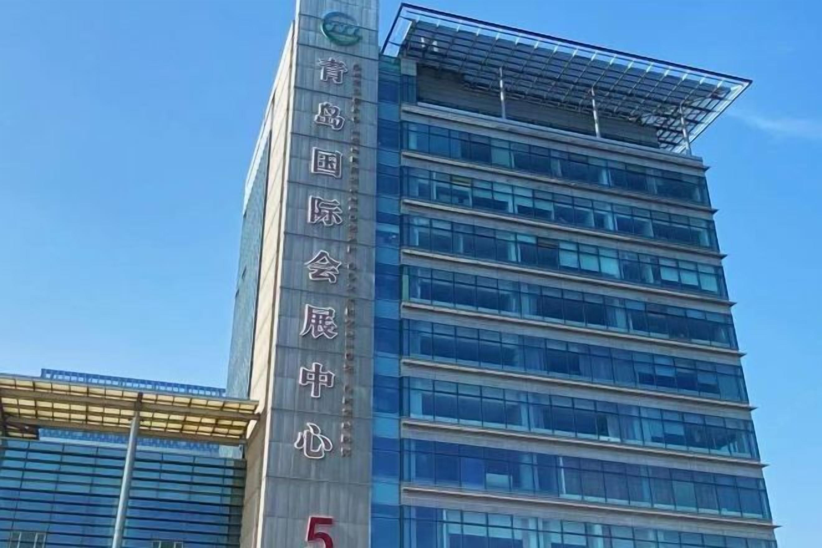 A modern building with a clear sign indicating it is the Qingdao International Conference Center.