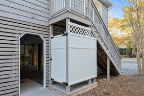 Uma casa com área externa coberta, escada e porta que dá para uma garagem.