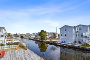 A waterfront property with a dock, a staircase leading to a second floor, and a view of the water. - Waterfront 4 Bedroom, 3 Bathroom, Bethany Beach Home With Canal Views! (South Bethany)
