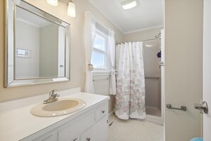 A bathroom with a large mirror, a sink, a shower, and a toilet. - Waterfront 4 Bedroom, 3 Bathroom, Bethany Beach Home With Canal Views! (South Bethany)