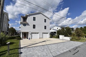 A two-story residential building with a garage, a front yard, and a paved driveway. - Bayside South Bethany Home (South Bethany)