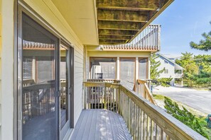 Ein Haus mit überdachter Veranda, einem Moskitonetz-Schutztür und einer sichtbaren Klimaanlage.