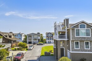 A coastal residential area with houses featuring balconies and a clear view of the sea.