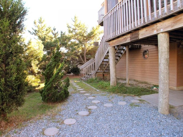 Un chemin menant à un bâtiment doté d’une terrasse en bois et d’une enseigne indiquant le numéro « 40 ».