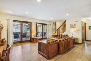 A spacious living area with a wooden bench, a staircase, and a view through glass doors. - Bethany Beach Coastal Retreat (South Bethany)