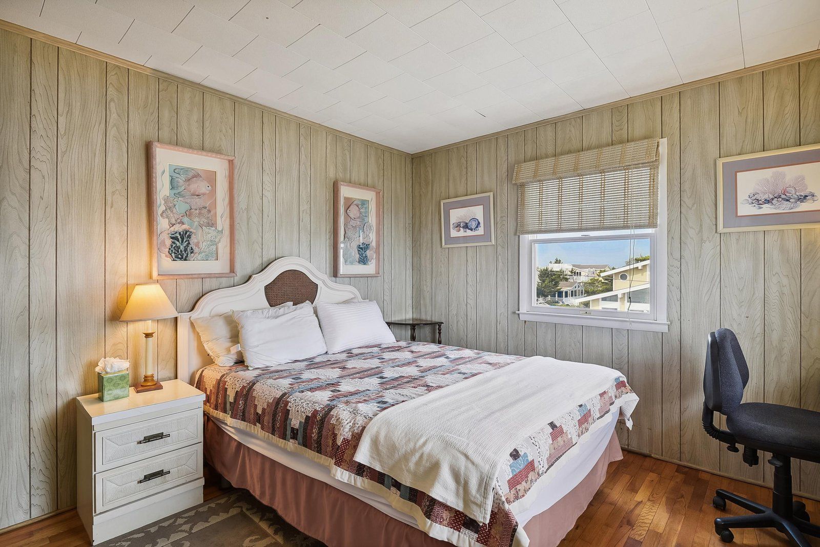 Une chambre à coucher avec un lit, une table de chevet, une lampe et une chaise.