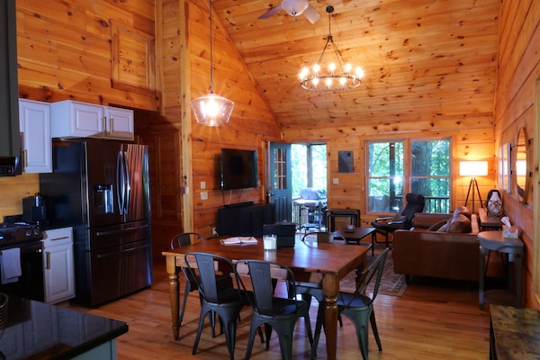 Open layout with vaulted ceilings connects kitchen, dining, and living.