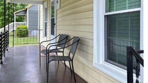 A covered porch with two chairs and a metal railing. - Historic Mill House
 (Lexington)