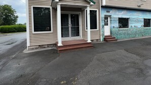 A two-story building with a porch and a mural on the side.