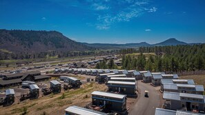 Un camping con varias cabañas, un edificio central y una carretera.