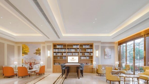 A spacious lobby with a central seating area, a large bookshelf, and a large window providing a view of the outdoors. - Vienna Hotel (Dongguan Houjie Avenue) (Dongguan)