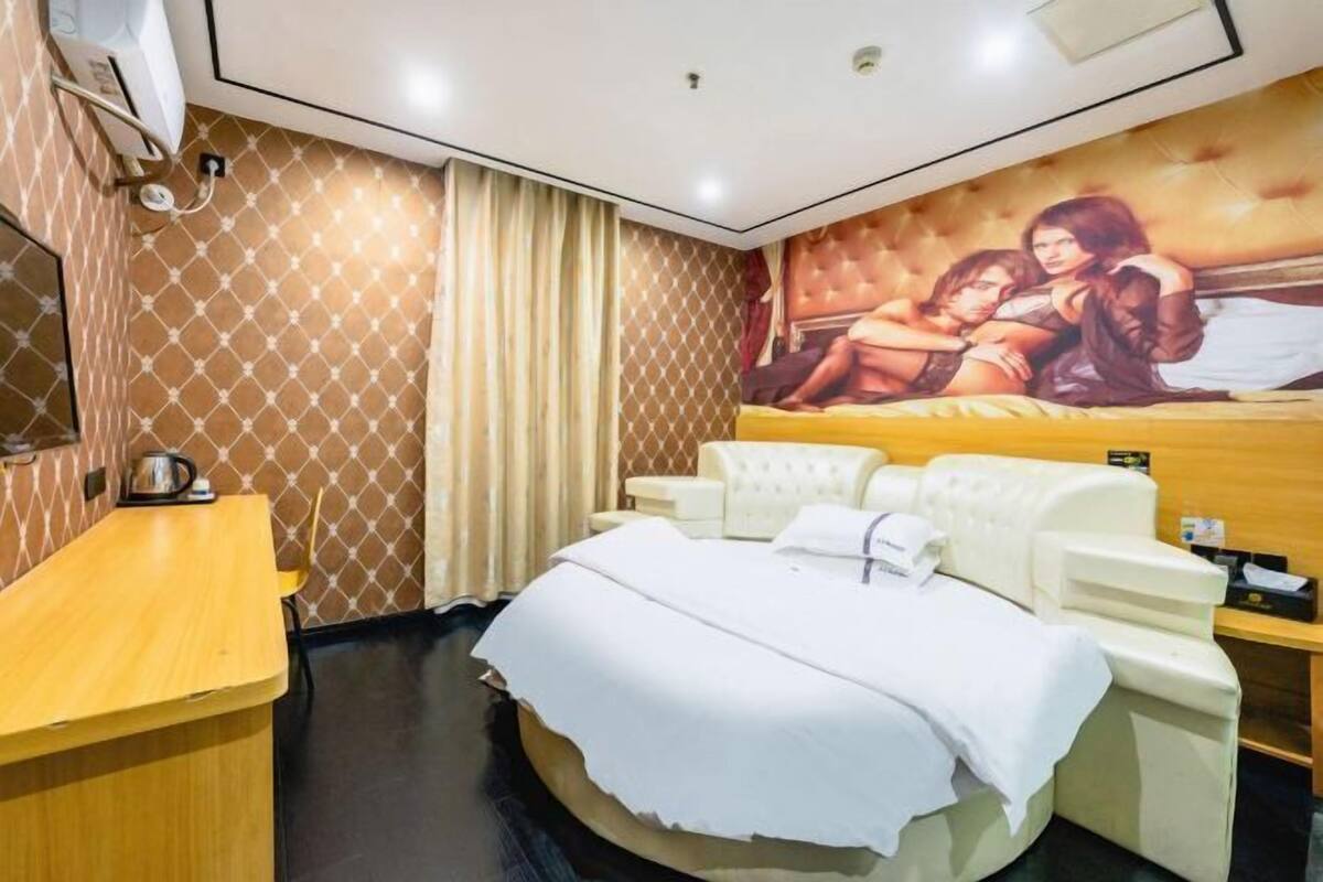 Une pièce comprenant un lit de massage, un bureau en bois et un appareil de massage fixé au mur.