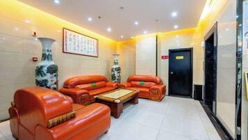 A lobby with leather sofas, a coffee table, and a large vase.