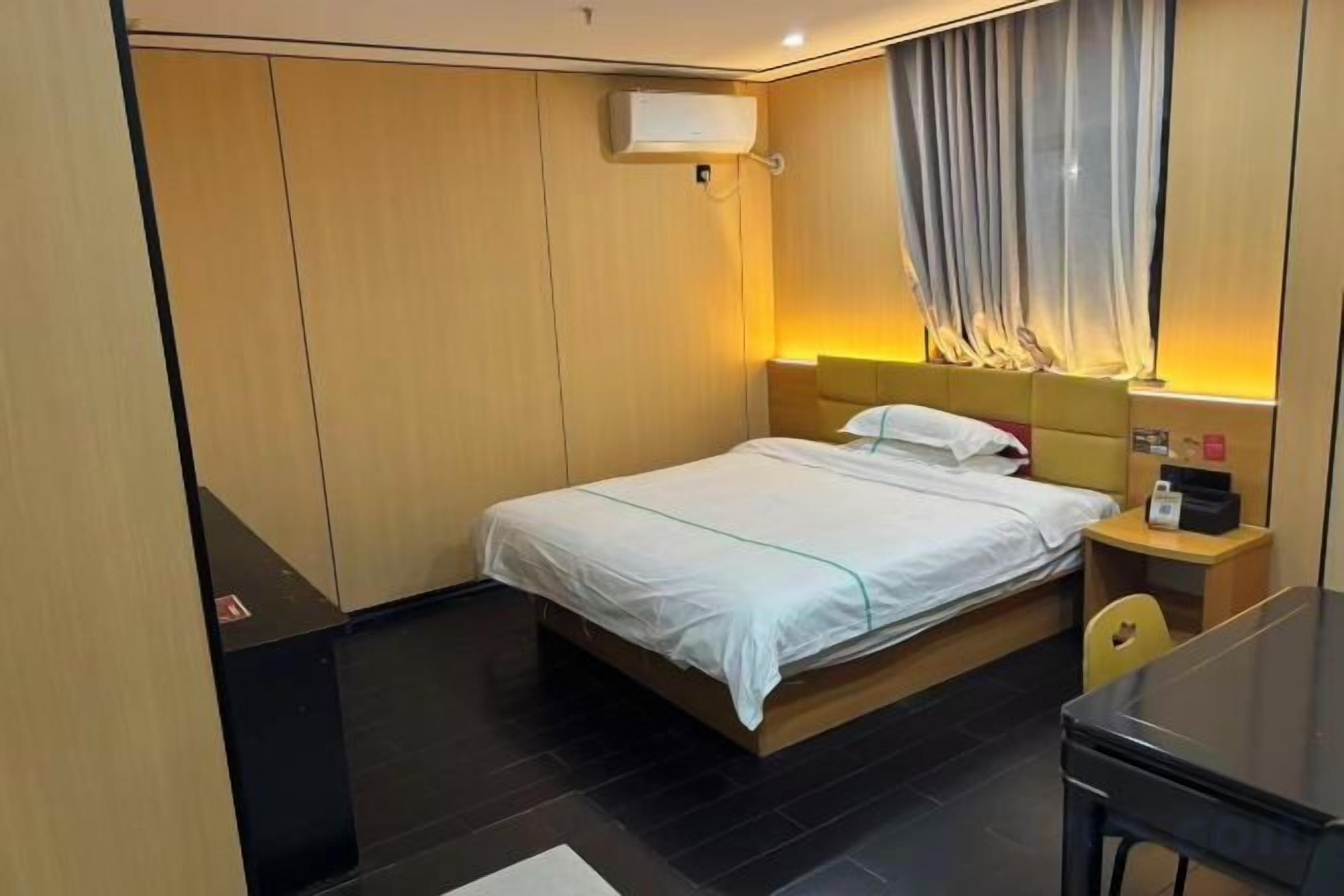 Une chambre d’hôtel avec un lit, une table de chevet et un bureau.