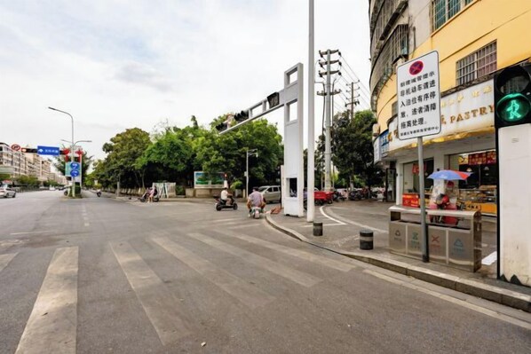 A street intersection with traffic lights, a pedestrian crossing, and a storefront with a sign. - Hongsheng Business Hotel (Nanchang)