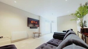A modern living room with a flat-screen TV mounted on the wall, a sofa, and a potted plant. - The Lodge · 3-Story Townhouse - Sleeps 8
Leeds City Centre  (West Yorkshire)