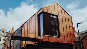A modern building with a sloped roof and a large garage door. - The Lodge · 3-Story Townhouse - Sleeps 8
Leeds City Centre  (West Yorkshire)