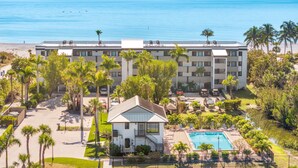 Ein Hotel mit Pool, Palmen und Blick auf den Ozean.