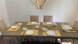 A dining table set with plates, bowls, and cutlery, with a bench in front. - The Castle at Camorene

 (Springfield)