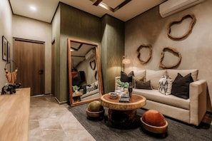 A modern living room with a sofa, coffee table, and decorative items.