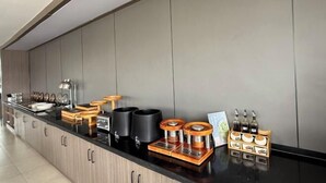 A modern kitchen with a black countertop, wooden cabinets, and various kitchen appliances and utensils. - Homeinn Hotel (Qingdao Zhengyang Middle Road Wanda Plaza) (Qingdao)