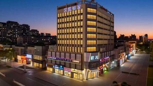 A modern hotel building with multiple floors and a prominent entrance. - Homeinn Hotel (Qingdao Zhengyang Middle Road Wanda Plaza) (Qingdao)