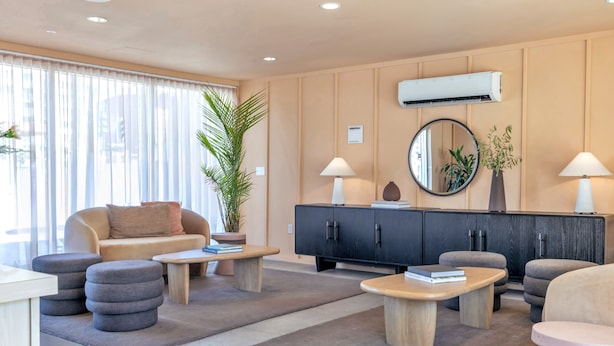 Una sala de estar moderna con un sofá, dos sillones, una mesa de centro y un aparador.