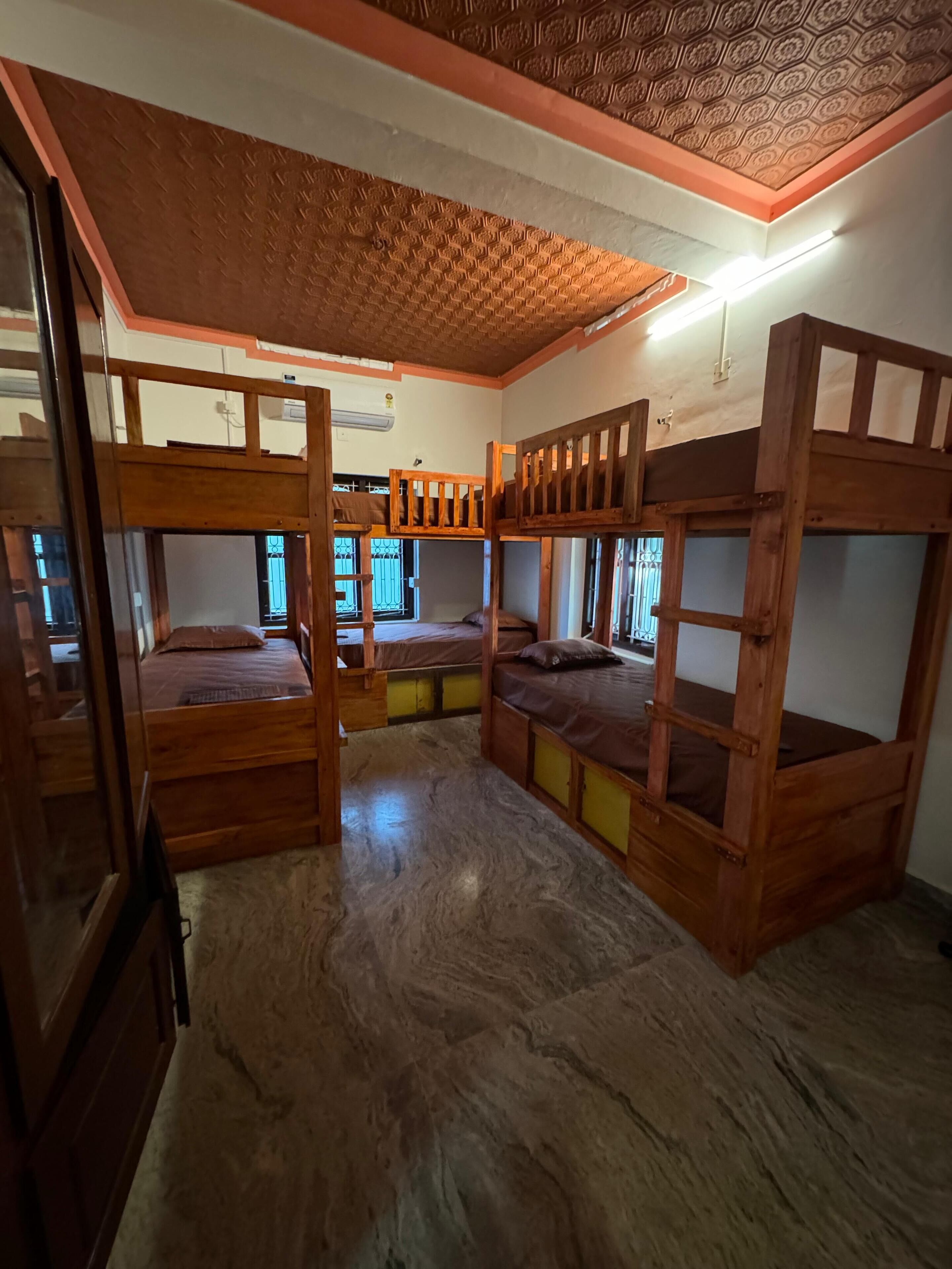 Una habitación con literas, techo de madera y pared decorada.