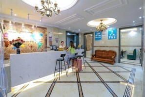 A hotel reception area with a reception desk, bar stools, a sofa, and a chandelier. - Lido Shuimu Hotel (Chengdu Shuangliu Airport Information Engineering University Store) (Chengdu)