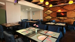 A restaurant with tables set for dining, featuring a modern interior with geometric wall patterns and pendant lighting. - Lido Shuimu Hotel (Chengdu Shuangliu Airport Information Engineering University Store) (Chengdu)
