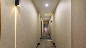 A long, narrow hallway with beige walls and a patterned carpet. - Lido Shuimu Hotel (Chengdu Shuangliu Airport Information Engineering University Store) (Chengdu)