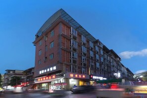 En byggnad med flera våningar, där bottenvåningen inrymmer kommersiella lokaler, inklusive en restaurang och en butik.