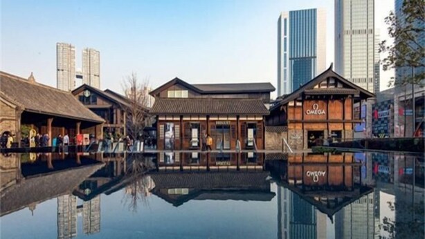 A traditional wooden building with a sign that reads "OMEGA" in a modern urban setting with tall buildings in the background. - Lido Shuimu Hotel (Chengdu Shuangliu Airport Information Engineering University Store) (Chengdu)