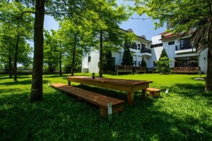 A picnic table in a grassy area with a building in the background. - Forest Bed and Breakfast(Pet friendly) (Hualien)
