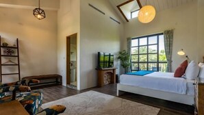 A room with a bed, a desk, a chair, a hanging light fixture, and a window. - Forest Bed and Breakfast(Pet friendly) (Hualien)