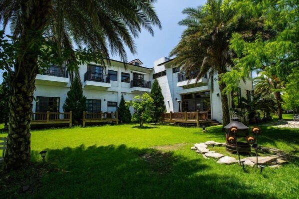 A hotel with multiple floors, outdoor seating, and lush greenery. - Forest Bed and Breakfast(Pet friendly) (Hualien)