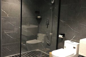Un baño moderno con ducha de vidrio, inodoro y lavamanos.