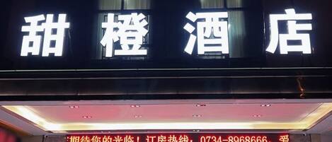 A hotel sign with Chinese characters and a contact number for booking.
