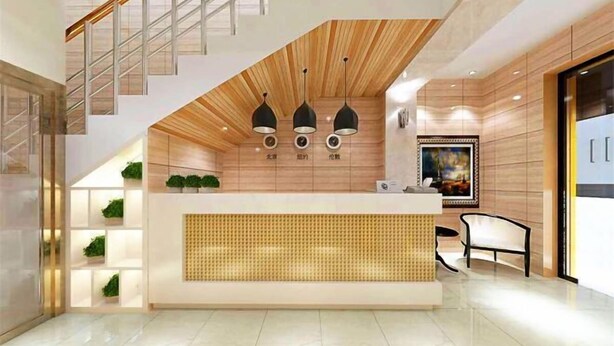 A modern reception area with a wooden reception desk, a staircase, and pendant lighting. - Shijiazhuang Yiyou Express Hotel (Youyi South Street Hebei Province Letters and Calls Bureau Branch) (Shijiazhuang)