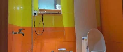 A bathroom with a toilet, a shower, and a window.