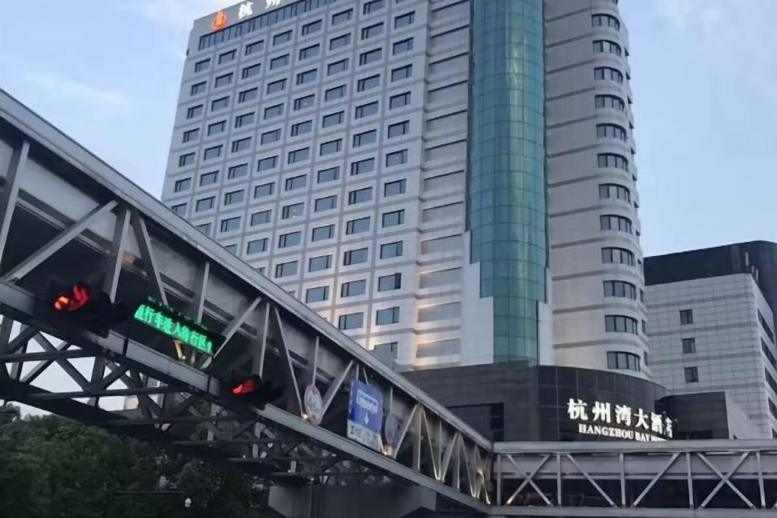 A multi-story building with a prominent vertical glass facade and signage indicating a hotel.