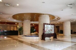 A spacious lobby with a central fountain, large columns, and a reception desk. - Hangzhou Bay Hotel (Hangzhou)