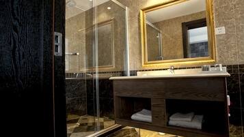 A modern bathroom with a glass shower enclosure, a wooden vanity, and a large mirror.
