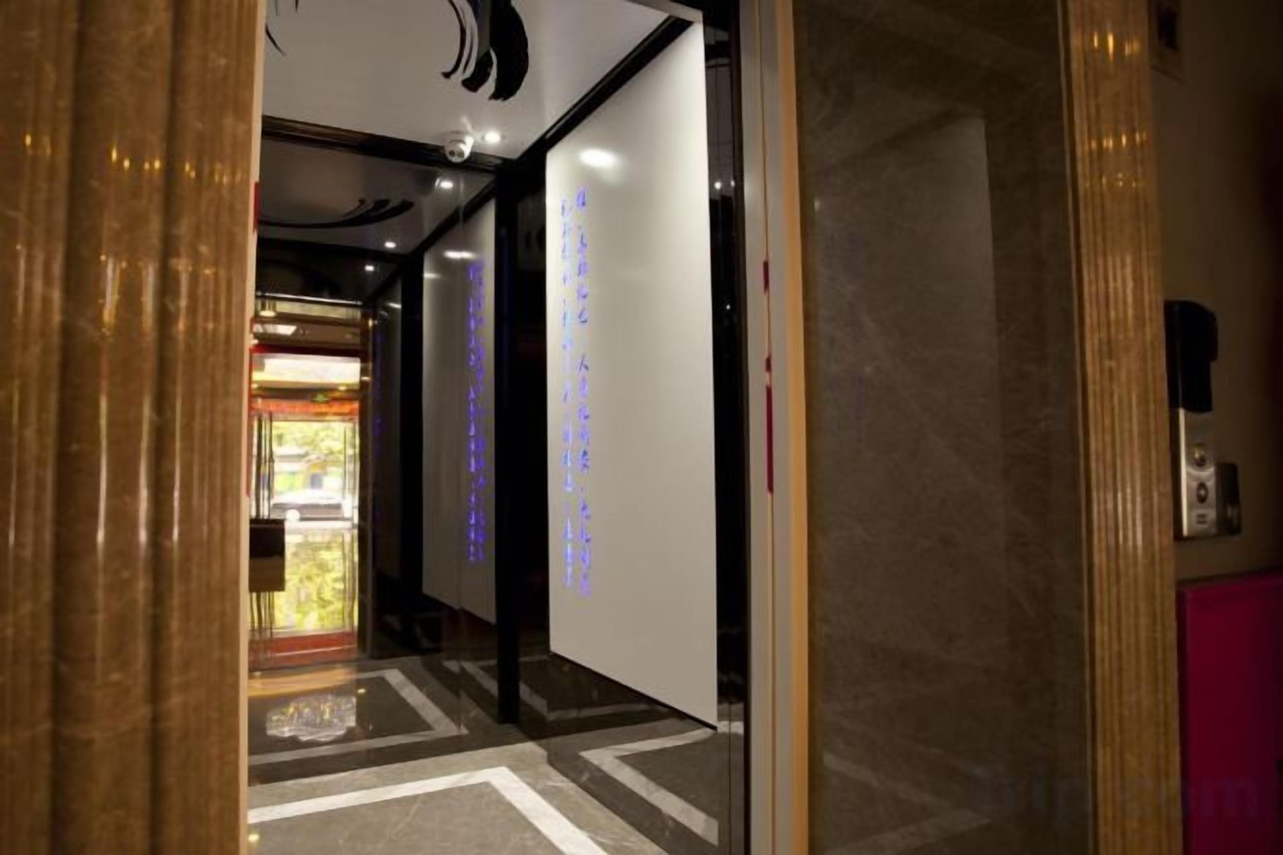A hotel corridor with a reception area visible in the background.