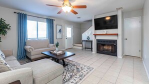 A living room with a sofa, coffee table, and fireplace. - Charming 2-bedroom, queen-bed, townhome in the center of Lafayette with AC, WiFi (Lafayette)