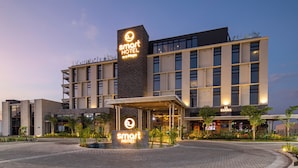 A modern hotel with a prominent 'smart hotel' sign, a covered entrance, and a landscaped area with plants.